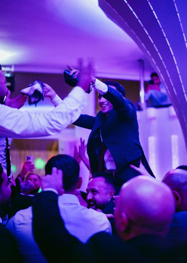 Gasten tillen een vriend op de neonverlichte dansvloer.